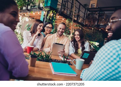 Photo of positive group students sitting cafe communicate speak use tablet prepare exam cafeteria indoors - Shutterstock ID 2207371205