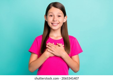 Photo Of Positive Happy Joyful Small Girl Hold Hands Chest Honest Child Smile Isolated On Teal Color Background