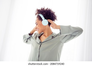 Photo Of Positive Inspired Lady Dance Listen Music Close Eyes Wear Headphones Silky Gown In Light Bedroom Home Indoors