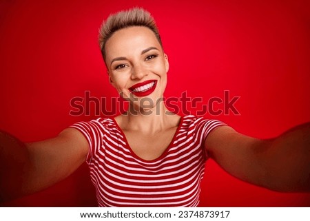 Photo of positive lovely girl wearing striped clothes blogging chatting followers isolated on red color background