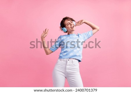 Photo of positive lovely lady have good mood listen music headphones dancing isolated on pink color background