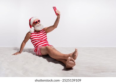 Photo of positive man wear red swimsuit making video video summer season isolated on white sandy beach background - Powered by Shutterstock