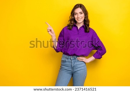 Photo of positive nice woman with wavy hairstyle dressed purple shirt directing at empty space promotion isolated on yellow background