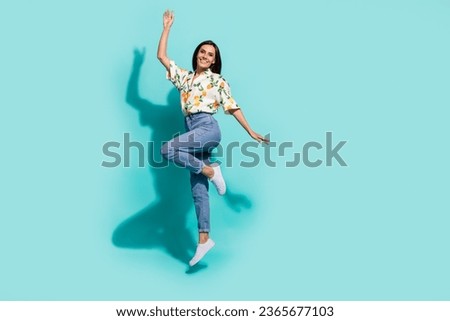 Photo of positive optimistic girl wear stylish clothes jumping up rejoice seasonal discount empty space isolated on cyan color background
