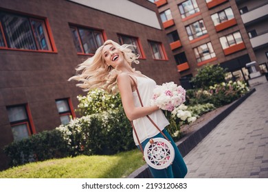 Photo of positive pretty blond hair lady enjoying free time honeymoon with her boyfriend hold blooming outside home