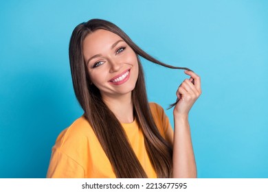 Photo Of Positive Pretty Sweet Gentle Lady Show Toothy Bright Smile Arm Touch Strand Hair Isolated On Blue Color Background