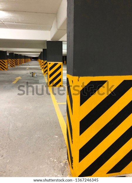 Photo of a potential danger diagonal stripes on a\
columns in a car park.