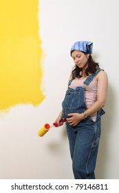 Photo Of A Pregnant Female Painting The Wall Of A Bedroom For Her Future Baby.