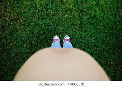 Photo Of A Pregnant Woman Belly Looking Down At Some Feet 