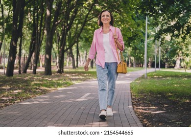 Photo of pretty adorable lady pensioner wear pink shirt walking smiling outdoors countryside garden