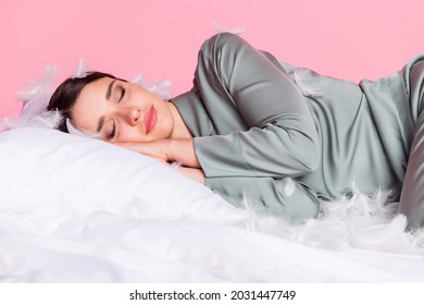 Photo Of Pretty Adorable Young Woman Nightwear Lying Duvet Feather Cover Face Closed Eyes Isolated Pastel Pink Color Background