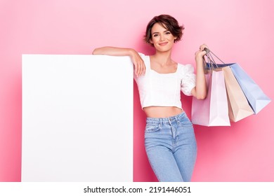 Photo of pretty beautiful lady wear white crop top rising shoppers empty space blank board isolated pink color background