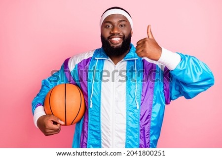 Photo of pretty charming dark skin guy dressed sport suit headband basketball showing thumb up isolated pink color background