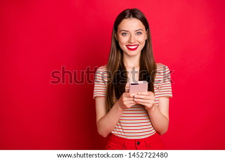 Photo of pretty charming funky lady in almost total red look holding checking-in her flight on smart phone isolated bright background
