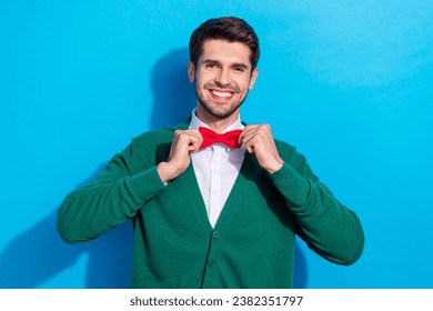 Photo of pretty charming guy dressed xmas green cardigan adjusting red bow tie isolated blue color background - Powered by Shutterstock