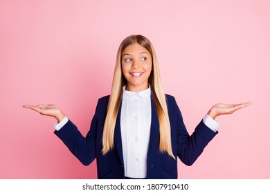 Photo Of Pretty Charming Little Lady Schoolkid Shiny Smiling Hands Hold Empty Space Look Side Suggest Better Option Wear Uniform Blue Jacket White Shirt Isolated Pink Color Background