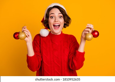 Photo of pretty cheerful funny excited lady celebrate winter holidays hold christmas balls present decorate green tree wear santa cap red knitted sweater isolated yellow color background - Powered by Shutterstock