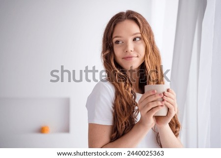 Photo of pretty creative minded girl hold hot coffee mug fantasize imagine enjoy free time bedroom apartment indoors