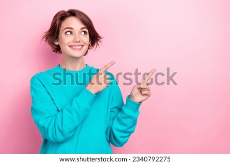 Photo of pretty curious woman indicating fingers empty space interesting poster wear oversize pullover isolated pink color background