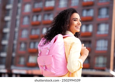 Photo of pretty curly hair good mood girl pink backpack wear yellow jacket walk outside urban city - Powered by Shutterstock