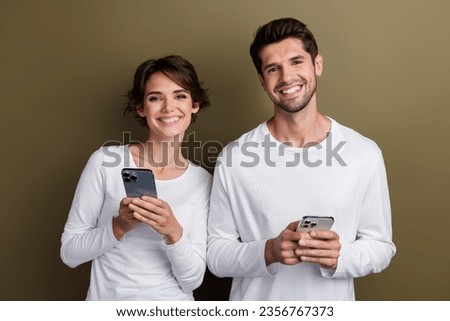 Photo of pretty cute wife husband dressed white shirts typing apple iphone samsung modern devices isolated brown color background