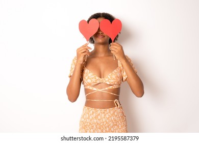 Photo Of Pretty Dark Curly Skin Lady Holding In Hands Little Red Paper Hearts Hiding Flirty Eyes Wear Summer Clothing Isolated White Background