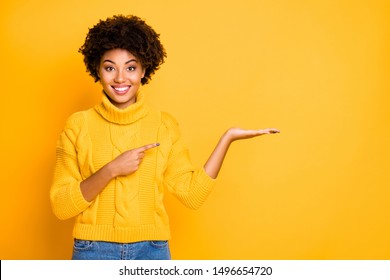 Photo of pretty dark skin lady promoter holding on arm best product for final low price wear warm jumper isolated yellow background