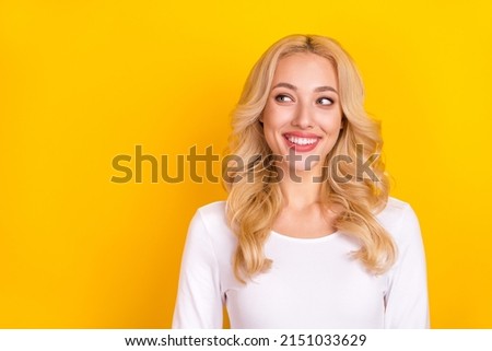 Photo of pretty dreamy lady dressed white shirt smiling looking empty space isolated yellow color background