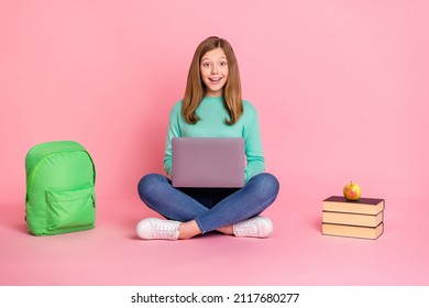 Photo of pretty excited girl wear turquoise sweater holding school supplies device isolated pink color background