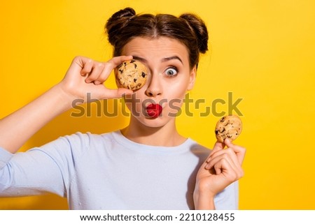 Photo of pretty flirty lady wear long sleeve holding biscuits cover eye pouted lips isolated yellow color background