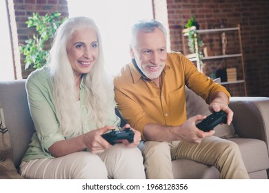 Photo Of Pretty Funky Pensioner Lady Gentleman Sitting Couch Enjoying Play Station Smiling Indoors House Flat