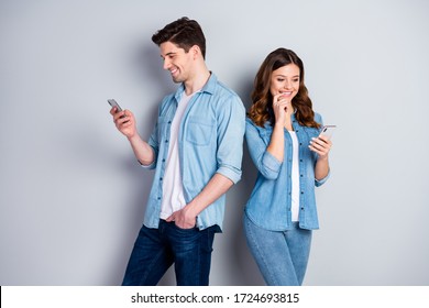 Photo pretty funny lady handsome guy couple look telephone screen do not care each other addicted users bloggers wear casual denim shirts outfit isolated grey color background