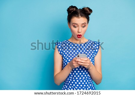 Photo of pretty funny lady open mouth hold telephone hands check comments new post see bad negative words wear dotted white blouse shirt isolated blue color background