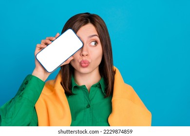 Photo of pretty girl pouted lips empty space telephone screen cover eye look empty space    isolated on blue color background - Powered by Shutterstock