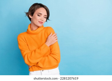 Photo of pretty lovely lady closed eyes hands hug shoulder empty space isolated on blue color background - Powered by Shutterstock