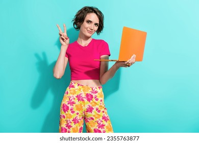 Photo of pretty lovely lady hold wireless netbook arm fingers demonstrate v-sign isolated on teal color background