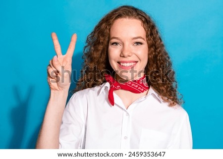 Photo of pretty lovely nice cheerful girl wear trendy white clothes showing v-sign symbol good mood isolated on blue color background