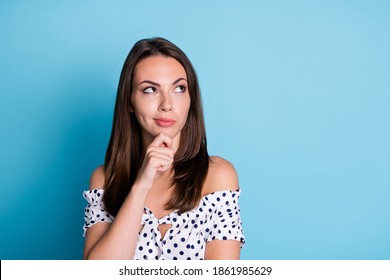 Photo of pretty minded young lady hand chin look empty space wear dotted blouse isolated blue color background - Shutterstock ID 1861985629