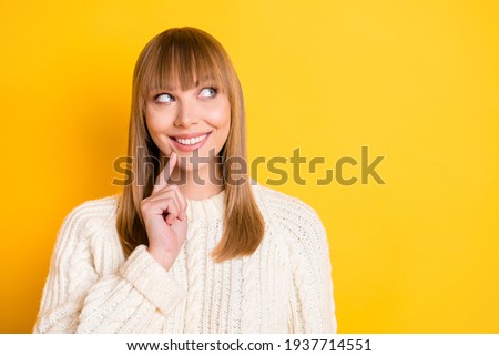 Photo of pretty person finger on chin toothy smile look empty space imagine wear knitted sweater isolated on yellow color background