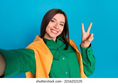 Photo of pretty positive person make selfie demonstrate v-sign isolated on blue color background
