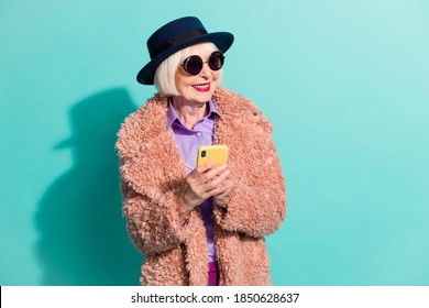 Photo of pretty senior lady wear retro jacket headwear eyeglasses writing device isolated teal color background