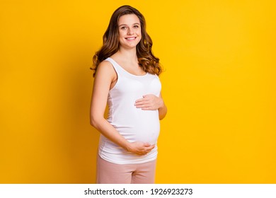 Photo of pretty shiny lady waiting baby dressed white clothes hugging tummy isolated yellow color background - Powered by Shutterstock