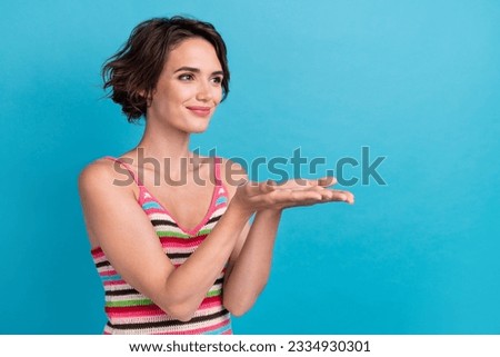 Photo of pretty shiny lady wear striped singlet looking holding arms empty space isolated blue color background