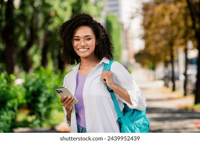 Photo of pretty sweet woman dressed white shirt backpack typing instagram twitter telegram facebook outdoors urban city park