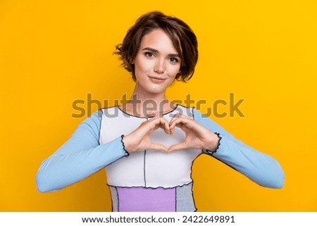 Photo of pretty sweet woman wear top smiling showing arms finders empty space isolated yellow color background