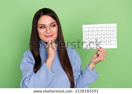 Photo of pretty young brunette lady look paper wear blue pullover eyewear isolated on green color background