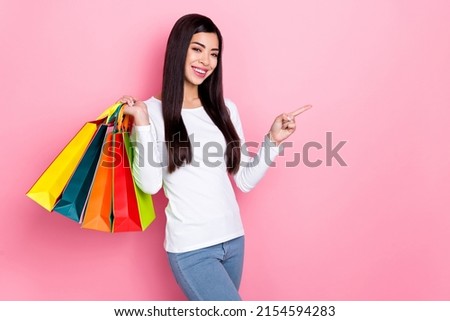 Photo of pretty young brunette lady hold bags index promo wear simple cloth isolated on pink color background