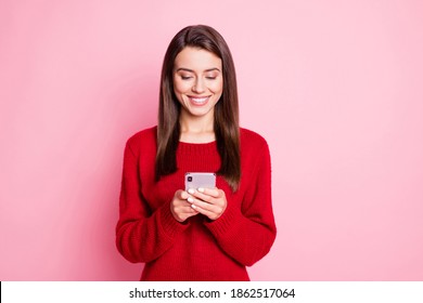 Photo of pretty young lady hold telephone look screen white smile wear red sweater isolated pink color background - Powered by Shutterstock