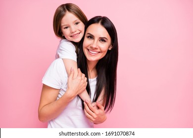 Photo of pretty young mommy hold arms hugging little daughter good mood lovely sincere cardiac feelings piggyback wear casual t-shirts jeans isolated pastel pink color background - Shutterstock ID 1691070874