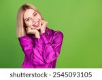 Photo of pretty young woman hands touch cheeks show tongue empty space wear purple shirt isolated on green color background